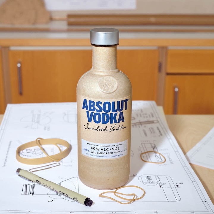 a bottle on a table on top of sketches